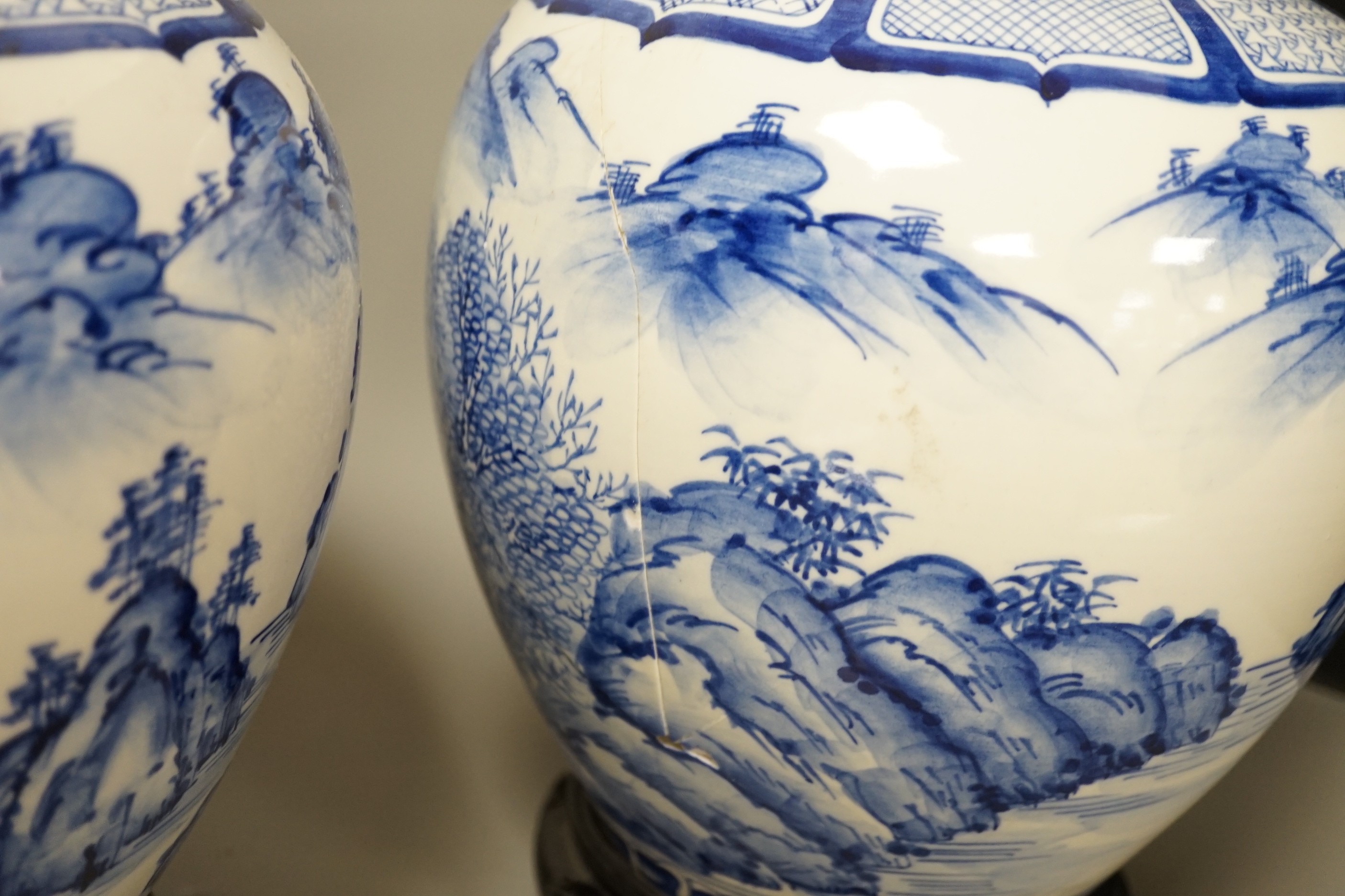 A pair of large Japanese blue and white vases, on wood stands, 26cms high of including stand.